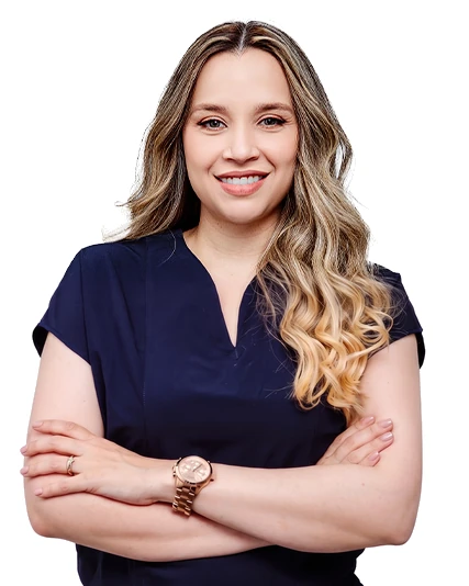 Dra. Danney Gómez, dermatóloga, de brazos cruzados y sonriendo.